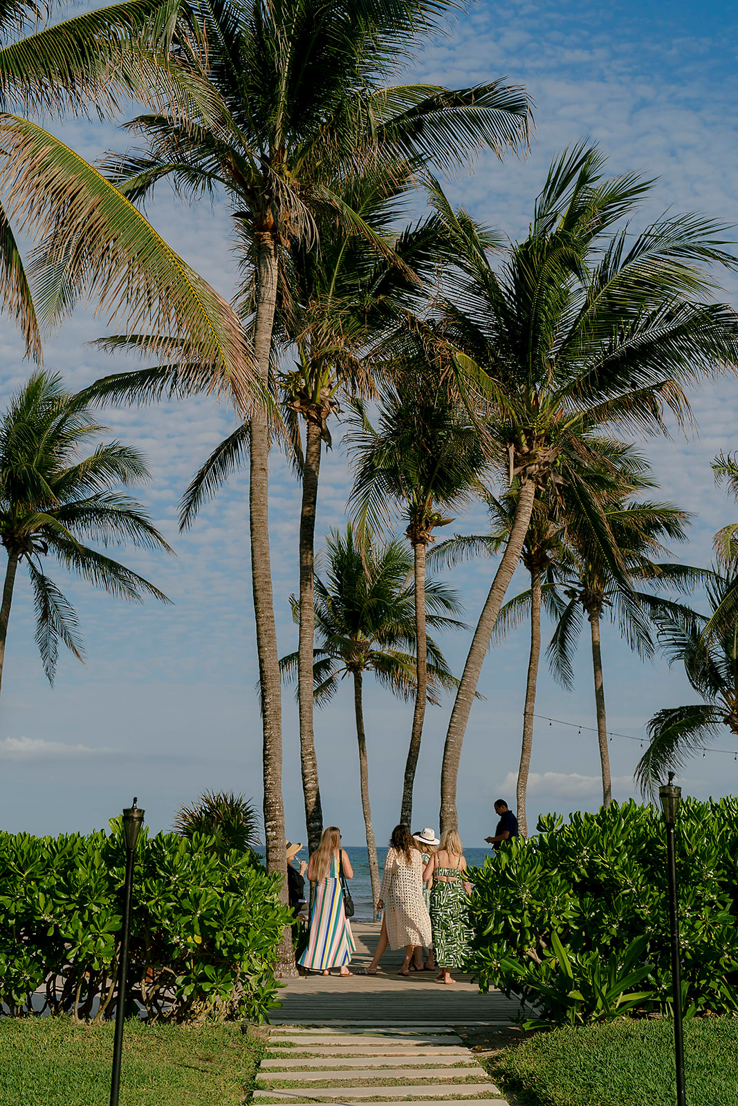 Refined cocktail hour setup during a destination wedding at Hotel Esencia in the Riviera Maya, with guests dressed in elevated warm-weather fashion